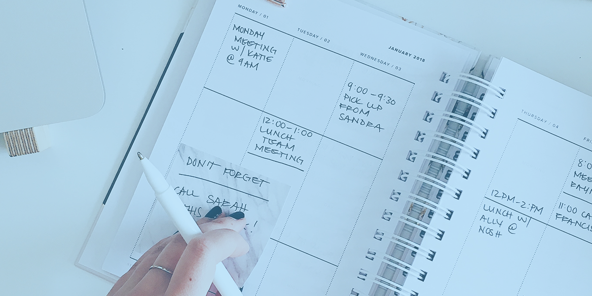 paper calendar, woman's hand with pen writing notes